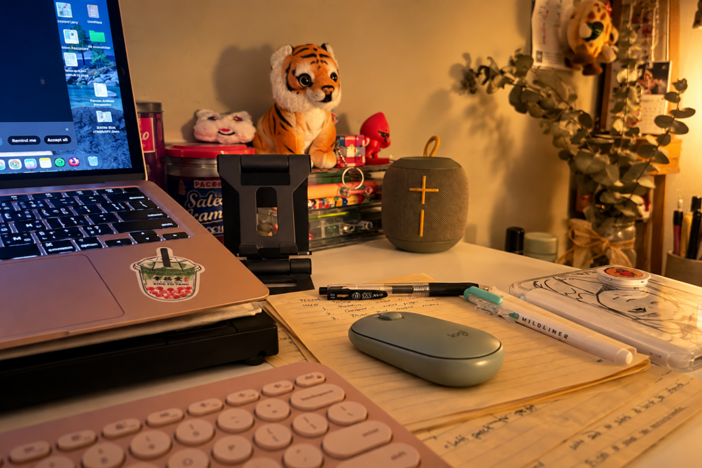 Laptop, keyboard, mouse and handwritten notes on a warm home workspace